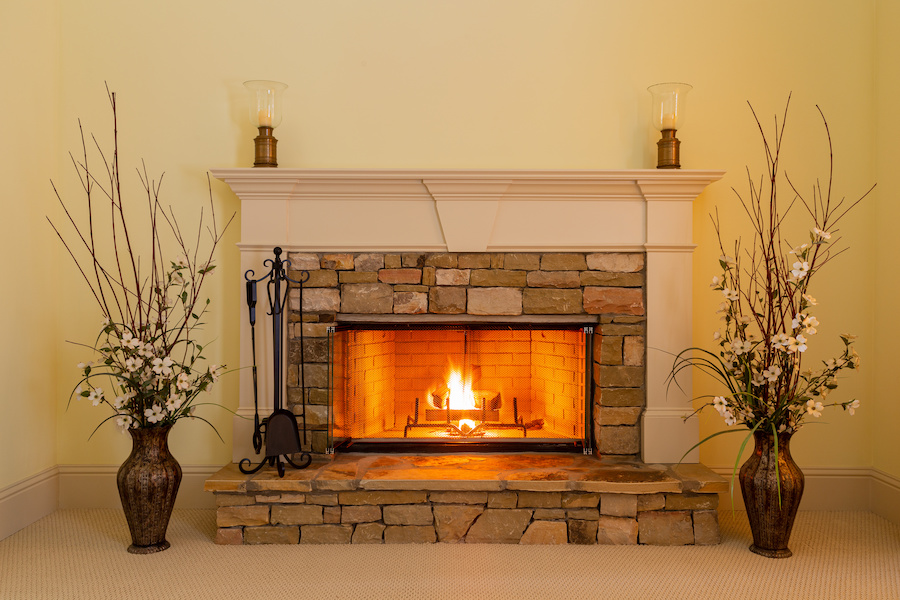 Romantic evening by a glowing fire in the elegant stone fireplace at home.