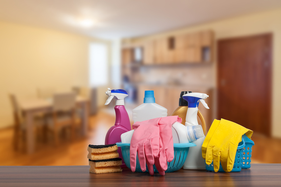 Home cleaning service concept with supplies. Close up of cleaning supplies in front of livingroom.