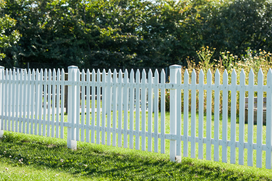 White picket fence in a garden in the summer