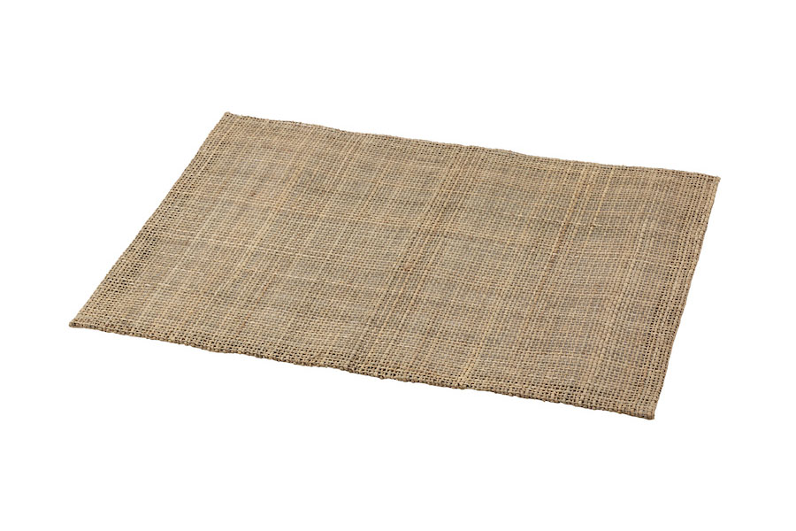 A woven luncheon mat on a white background. View from an angle